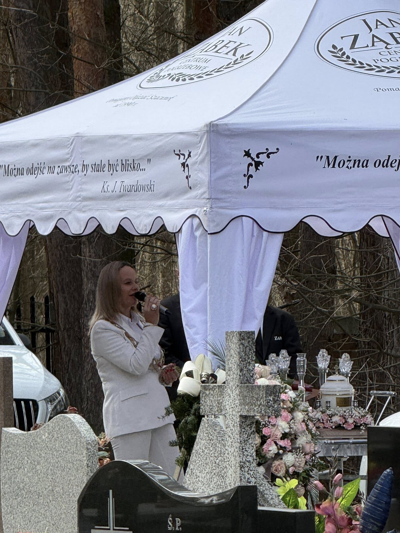 istrzyni ceremonii pogrzebowej Aneta Dobroch wygłasza osobistą mowę pożegnalną przez mikrofon podczas ceremonii pogrzebu świeckiego.